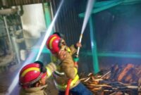 Petugas Damkar saat melakukan pembasahan titik api