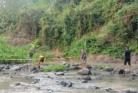 petugas dibantu warga hendak mengevakuasi mayat korban 