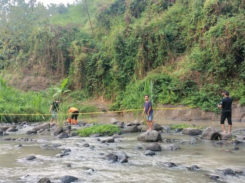 petugas dibantu warga hendak mengevakuasi mayat korban
