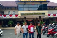 Kuasa hukum Mangkin saat menunjukkan tanda bukti laporan polisi