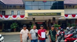 Kuasa hukum Mangkin saat menunjukkan tanda bukti laporan polisi