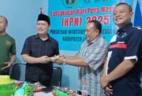 Foto saat ketua PWI menyerahkan potong tumpeng ke Kadis Kominfo