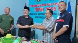 Foto saat ketua PWI menyerahkan potong tumpeng ke Kadis Kominfo