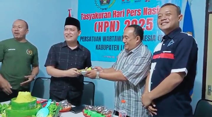 Foto saat ketua PWI menyerahkan potong tumpeng ke Kadis Kominfo