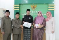 Basnaz saat menyerahkan bantuan biaya pengobatan