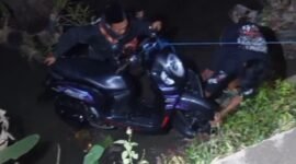 Warga saat membantu mengevakuasi motor korban