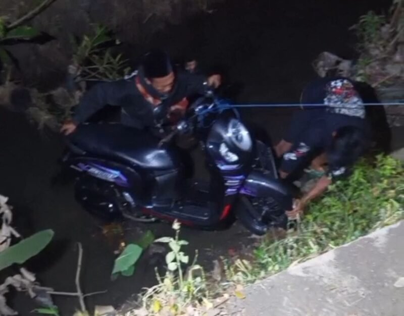 Warga saat membantu mengevakuasi motor korban