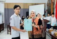 Ketua Tim Penggerak PKK Kabupaten saat menyerahkan ijazah salah satu lulusan