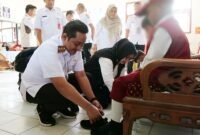 Bupati Lumajang didampingi  Wabup saat membagikan sepatu sekolah gratis