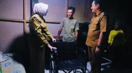Bupati didampingi Wabup saat menyerahkan bantuan kursi roda pada penderita tumor otak