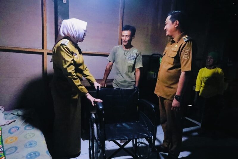 Bupati didampingi Wabup saat menyerahkan bantuan kursi roda pada penderita tumor otak
