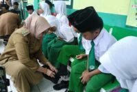 Bupati bersama Wakil Bupati Lumajang saat memberikan bantuan sepatu terhadap belasan siswa MI Miftahul Ulum 