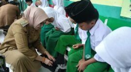 Bupati bersama Wakil Bupati Lumajang saat memberikan bantuan sepatu terhadap belasan siswa MI Miftahul Ulum 