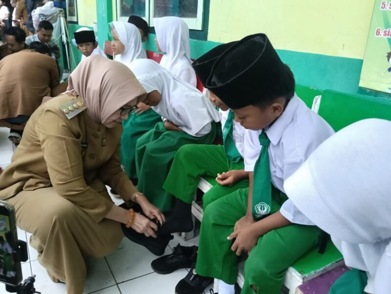 Bupati bersama Wakil Bupati Lumajang saat memberikan bantuan sepatu terhadap belasan siswa MI Miftahul Ulum 