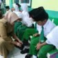 Bupati bersama Wakil Bupati Lumajang saat memberikan bantuan sepatu terhadap belasan siswa MI Miftahul Ulum 