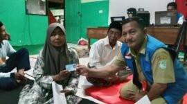 Petugas Dispendukcapil saat menyerahkan KTP salah satu pengungsi
