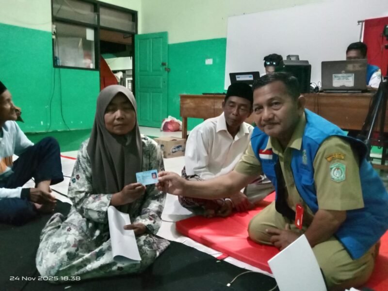 Petugas Dispendukcapil saat menyerahkan KTP salah satu pengungsi
