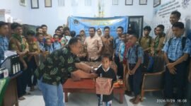 Ketua PWI Lumajang saat menyerahkan bantuan secara simbolis kepada salah satu anak yatim di LKSA Muhammadiyah