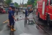 Petugas Damkar ketika melakukan pembersihan tumpahan solar jalur Pasirian Lumajang