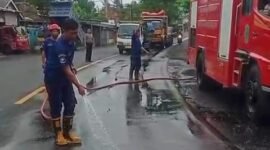 Petugas Damkar ketika melakukan pembersihan tumpahan solar jalur Pasirian Lumajang