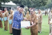 Sekda Lumajang saat menyerahkan tali asih kepada PNS purna tugas